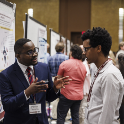 two men talking about a poster presentation