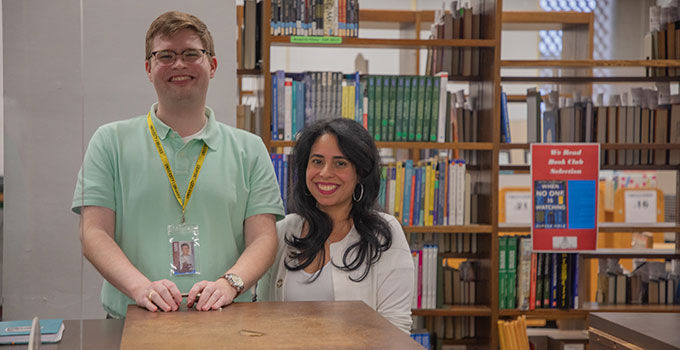 Two smiling librarians surrounded by books