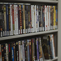 Close up of two library shelves filled with DVD cases.
