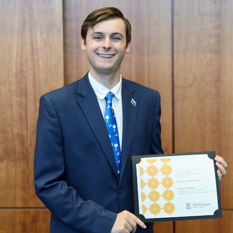 Zachary Gardner holding his award