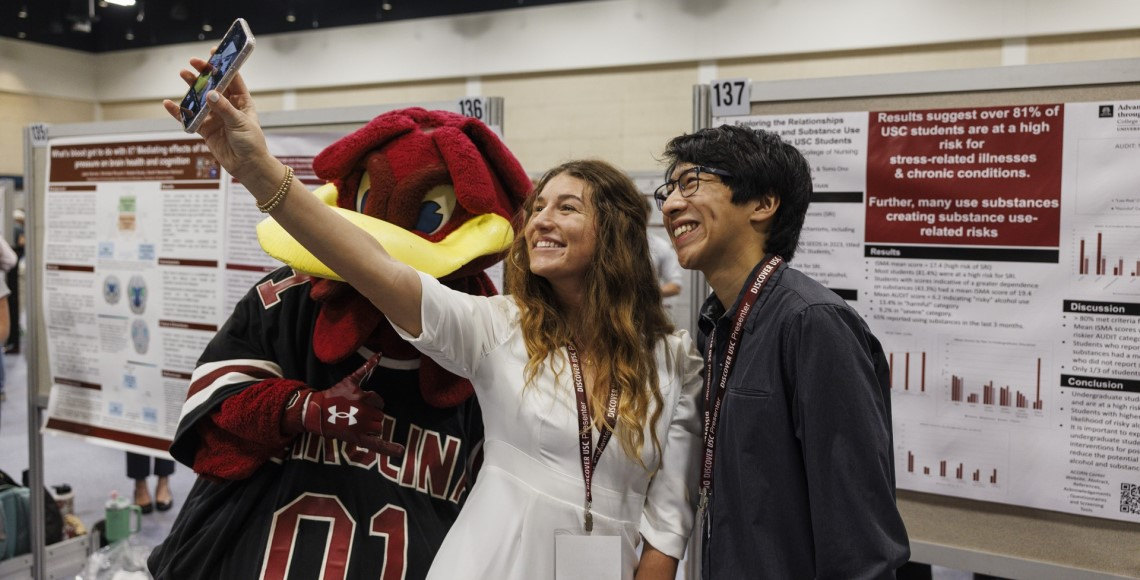 Two Discover USC presenters take a selfie with Cocky at Discover USC 2024.