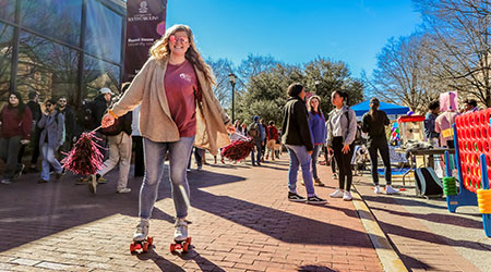 Student wearing rollerskates hanging out at an event on Greene Street.