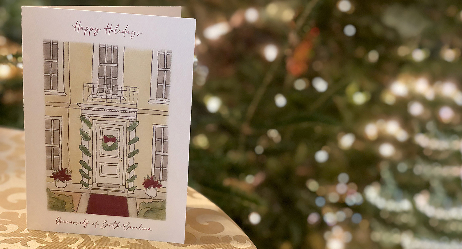 The 2022 holiday card sits on a table with white lights blurred out in the background