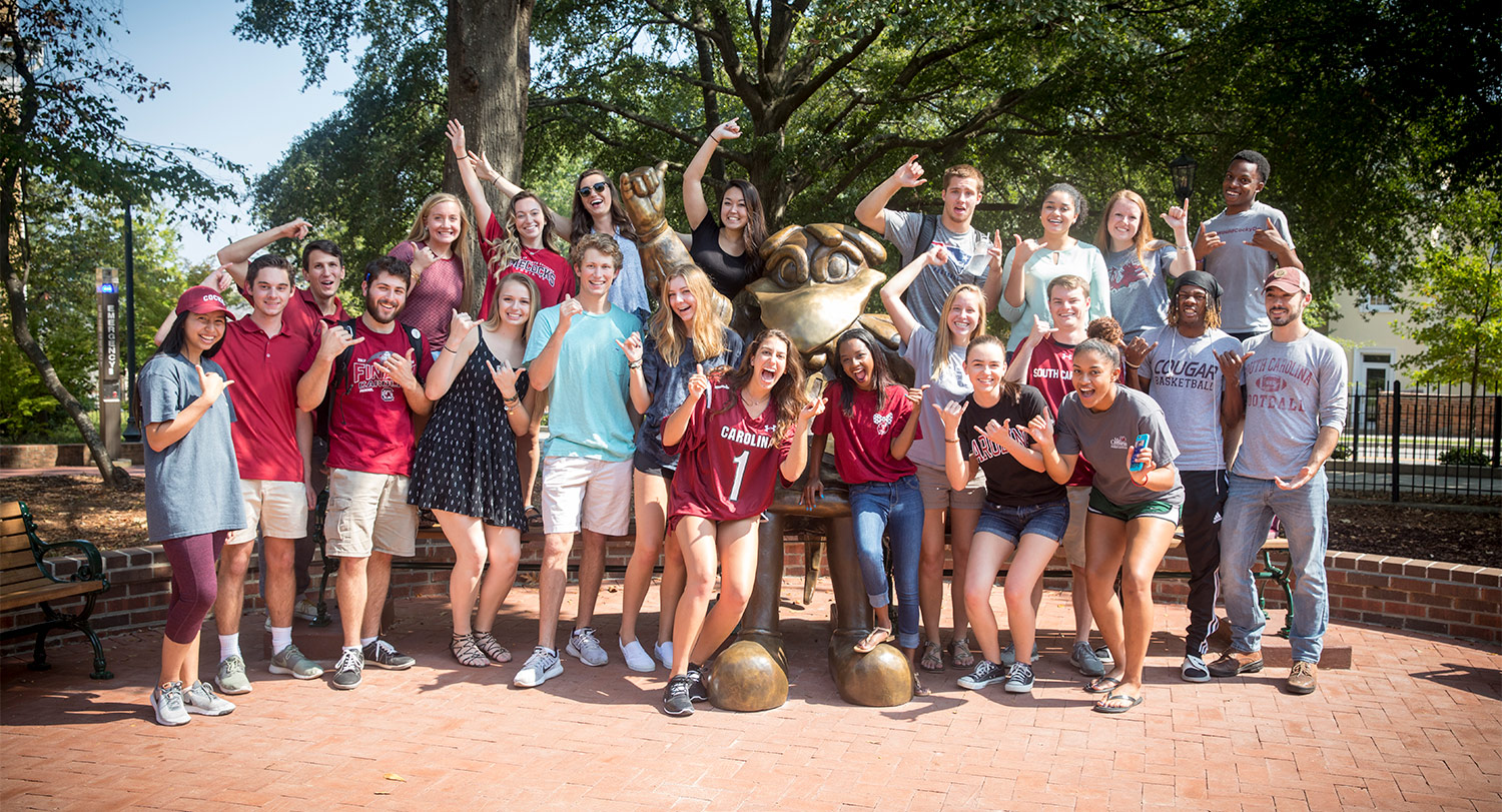 a large group of students pose with the Cocky statue