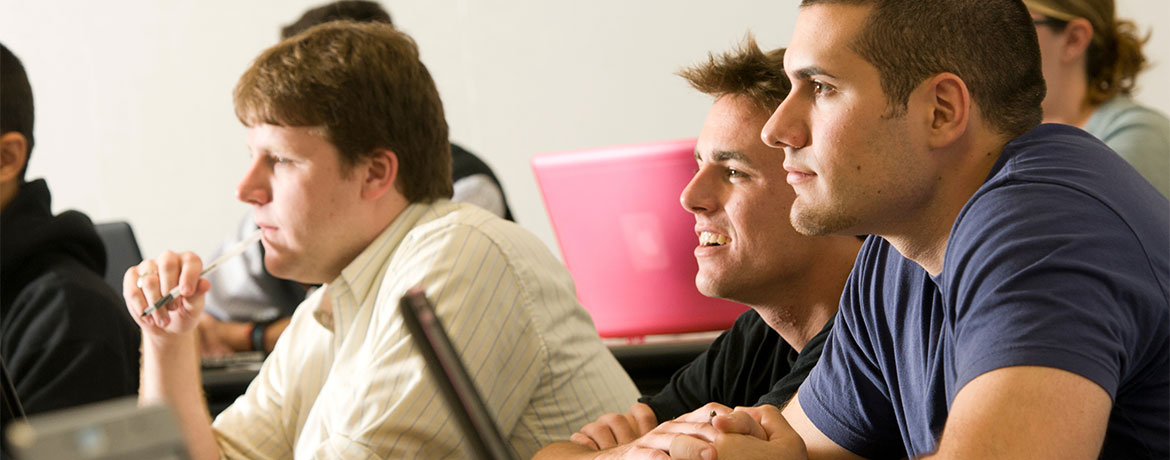 students smiling while listening to a lecture