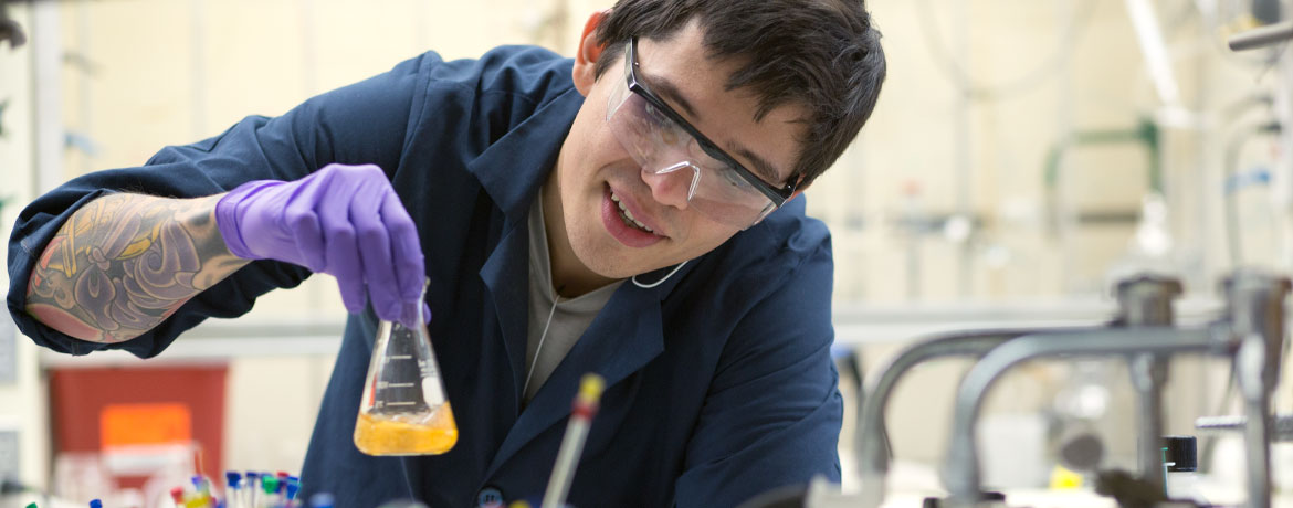 student holding beaker of liquid for experiment