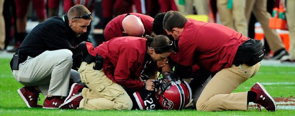 trainers helping a football player