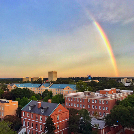 A rainbow hangs over campus on a beautiful evening
