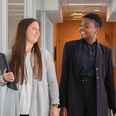 Two business professionals walking down a hallway.