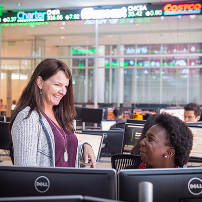 Professor talking to student in computer lab.