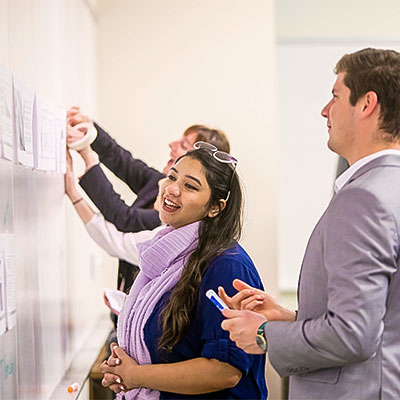 Students talking together at a whiteboard.