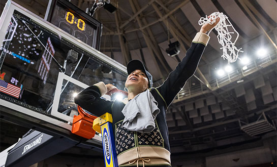 Coach Dawn Staley cuts down the net after the win in the Elite Eight tournament game.