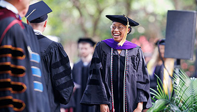Law student wearing a cap and gown during a commencement ceremony.