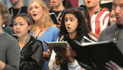 Large choir singing at practice. 