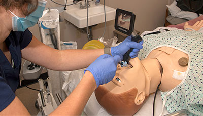 Student working with a mannequin in the simulation lab.