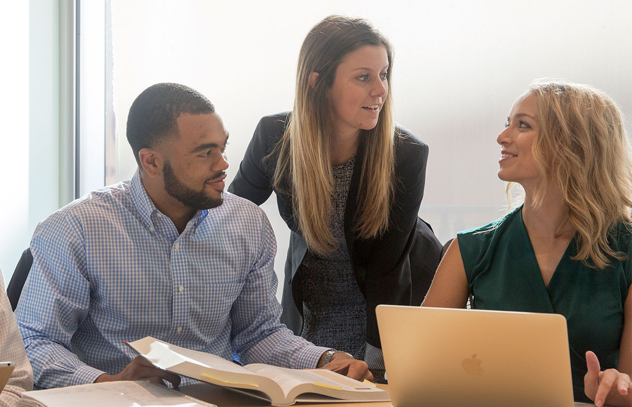 Three business professionals talking in a meeing.