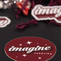 a close-up of Imagine Carolina stickers on display