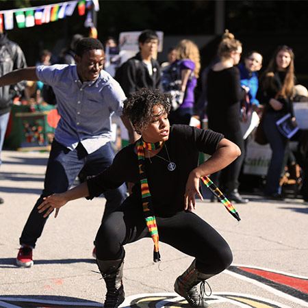 Two students dancing on green street during a Hip Hop Wednesday. 