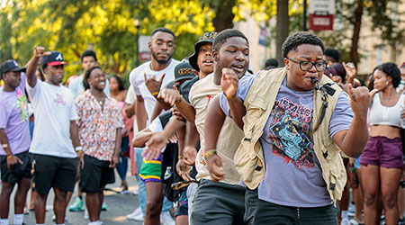 Students dancing in a line on Green Street. 