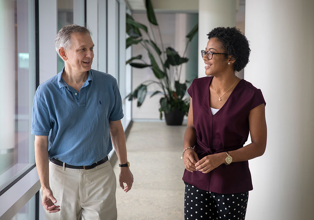 A professor and student in a hallway talking