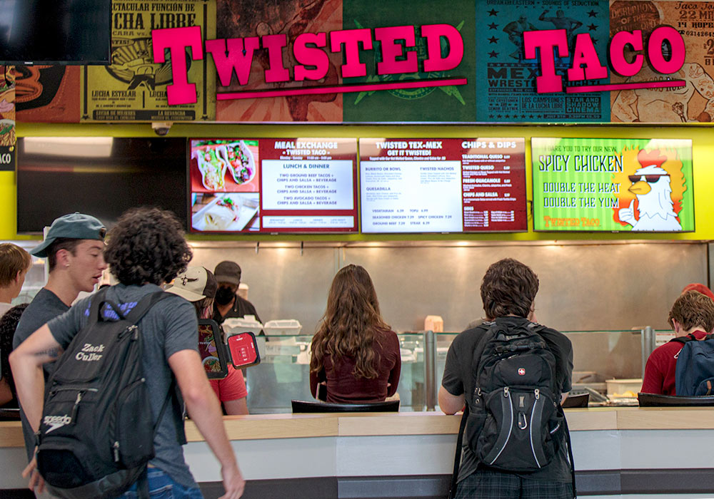 Student ordering food at the Twisted Taco restaurant counter. 