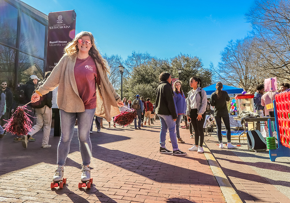Student wearing roller skates on Green Street at an event.