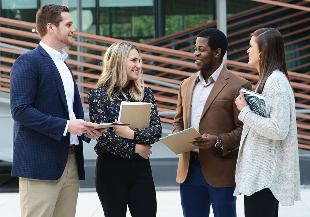 Young professional talking outside in a courtyard.