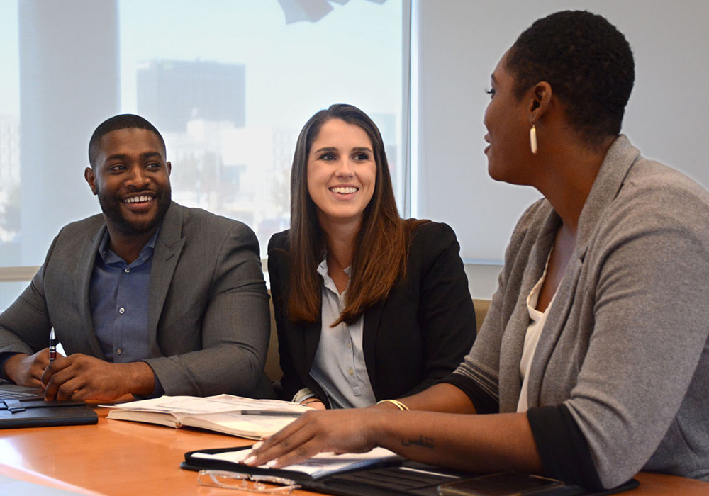 Young professional in a meeting at a conference room table.