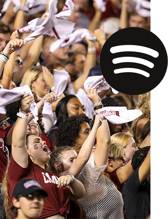 Gamecock fans cheering in the stands at a football game with a Spotify logo on top of the image. 