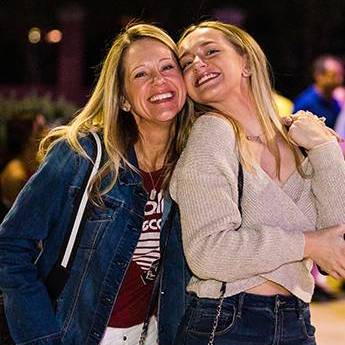 a mother and daughter embraced and smiling at the Rock the Roost event outdoors during Family Weekend