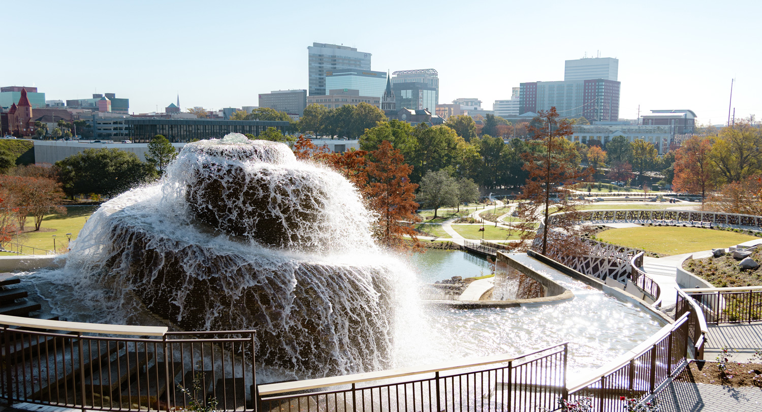 Finlay Park waterfall with downtown Columbia, South Carolina skyline in the background on a clear day.