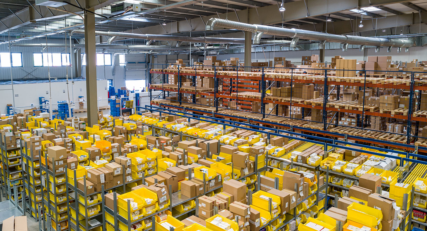 a large warehouse with shelves of boxes stacked to a high ceiling