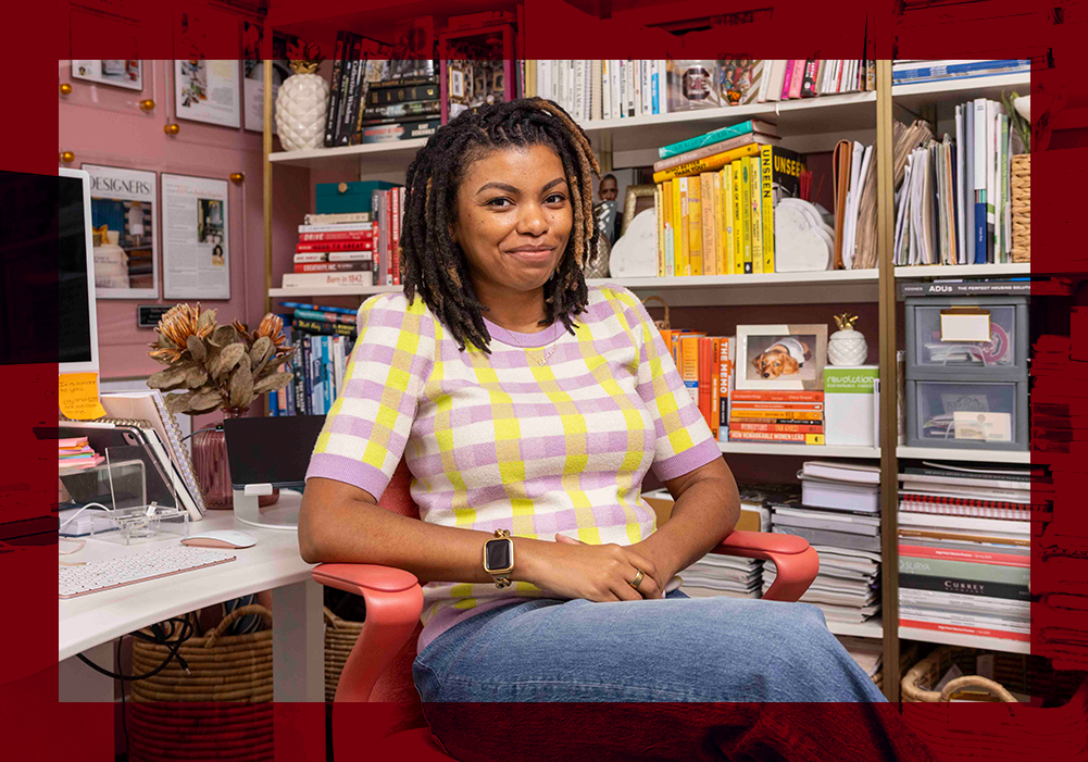 Amber Guyton sits in her design studio surrounded by books, artwork and creative materials.