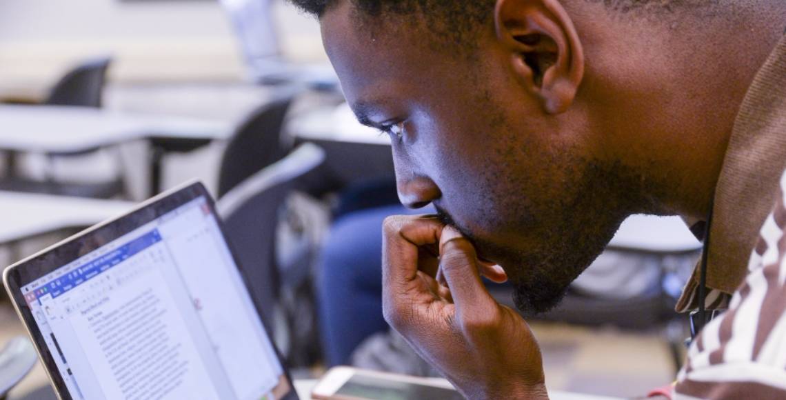 man looking at laptop screen and thinking