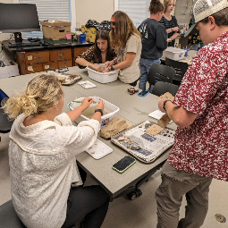 students washing artifacts found at Sesquicentennial 