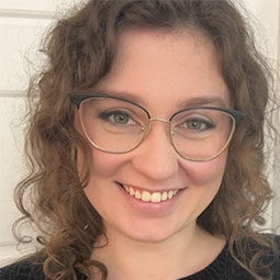 a woman with glasses and curly brown hair