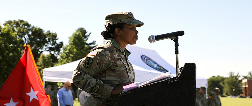 Chaplain Frances Igboeli speaks at the podium at an outdoor U.S. Army event.