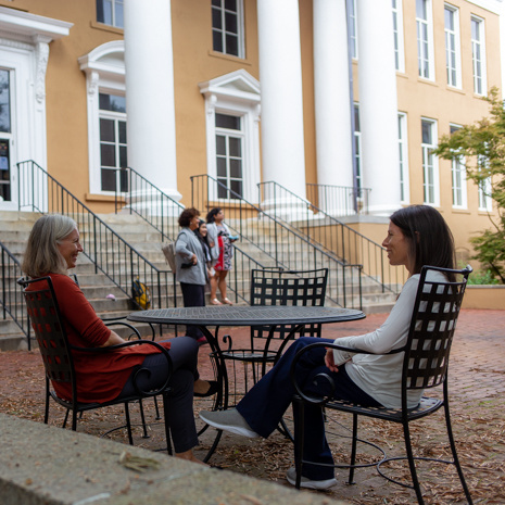Two professors sitting on patio of Barnwell college