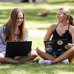 two female students smiling and working on the horseshoe