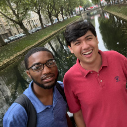 Jahleel Johnson stands to the left of another student in front of a waterway in Germany.