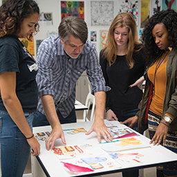 Art professor works with students on a painting
