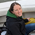 woman outside on a boat in the ocean with equipment