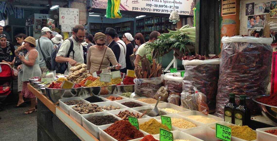 Two people peer over the selection at an outdoor spice market