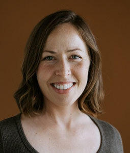 Headshot of Kathleen Broussard against an orange background