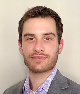 a man in a gray suit and dark hair