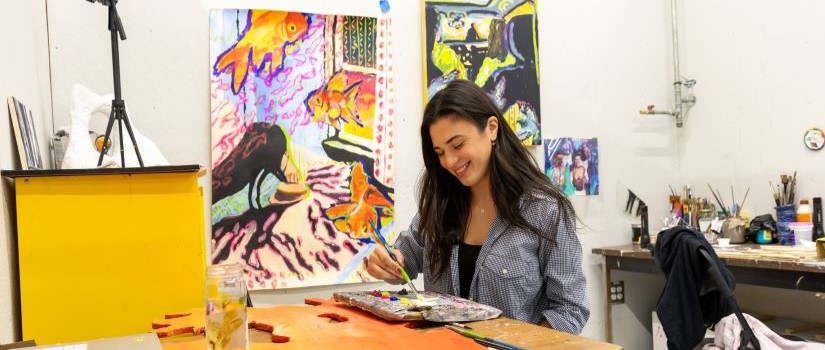 Graduate student painting in her studio at 707 Catawba