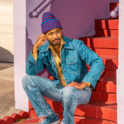 Chaz Bundick sits and poses on a colorful staircase.