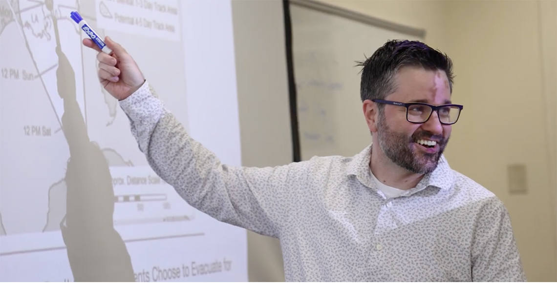 Professor Darin Freeburg pointing to a chart on the whiteboard