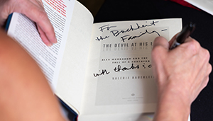 hands showing Valerie Bauerlein signing a book to the Buchheit family