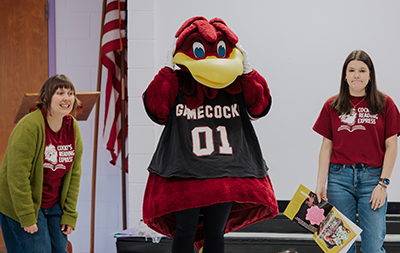 Margaret Cook Jackson and MLIS student Allison Hall (right), assisted by Cocky, read a book at Sandel Elementary School.